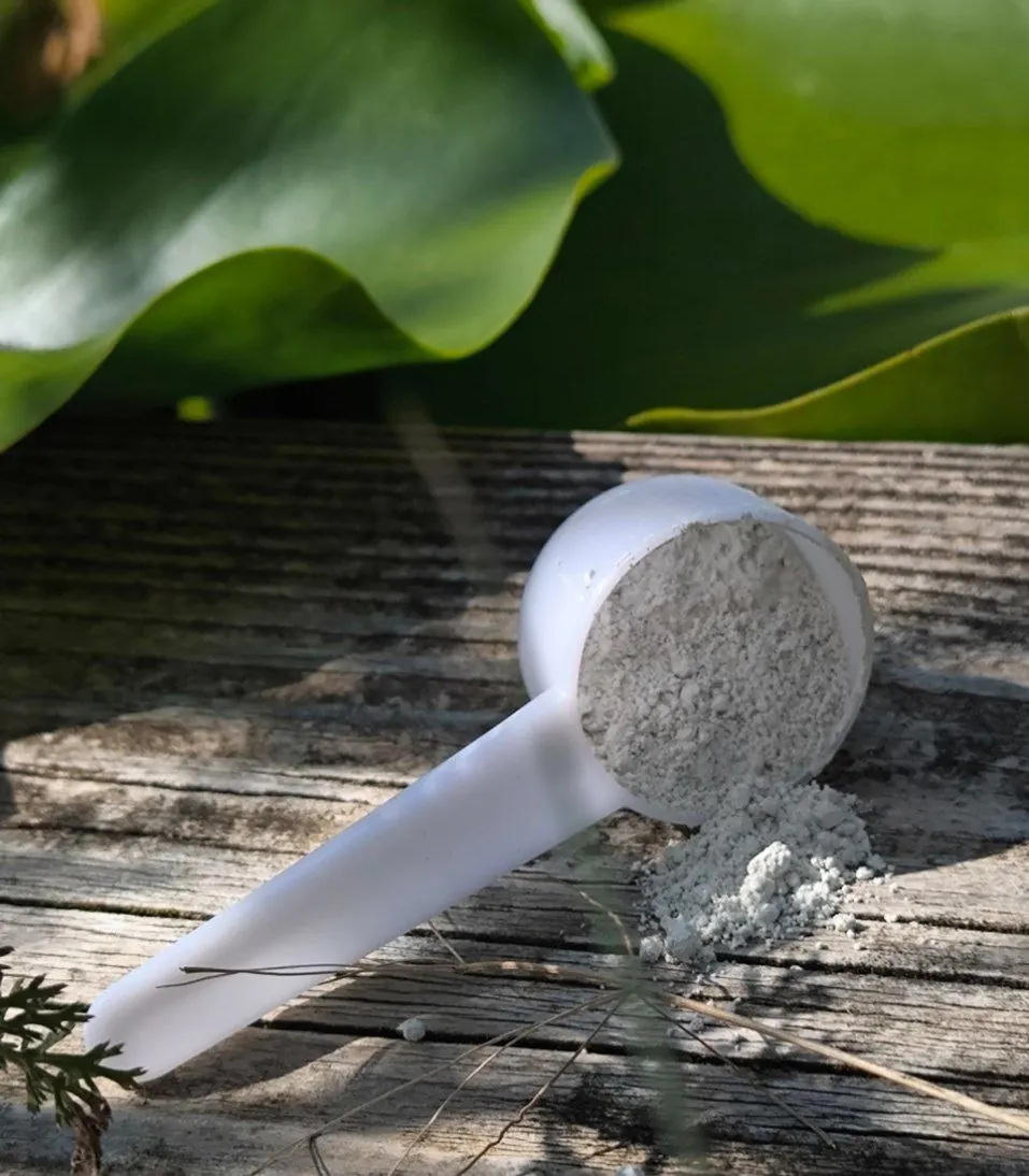 Messlöffel mit weißem Pulver auf Holz