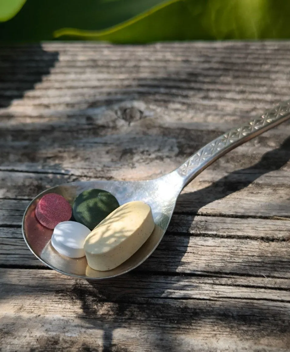 Tabletten auf einem Löffel im Sonnenlicht